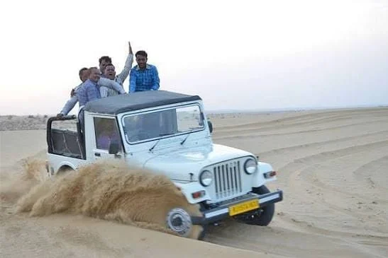 Guests standing in a jeep during a dune drive