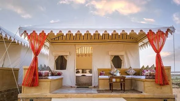 A Swiss tent with a shaded verandah and red drapes